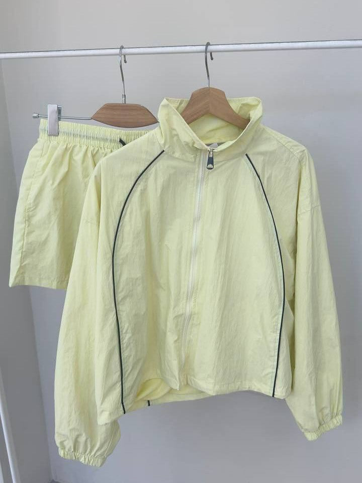 Damen gekürztes Windjacke-Set mit Stehkragen, kontrastierender Paspelierung und elastischer kurzer Freizeit-Hose – Célinea