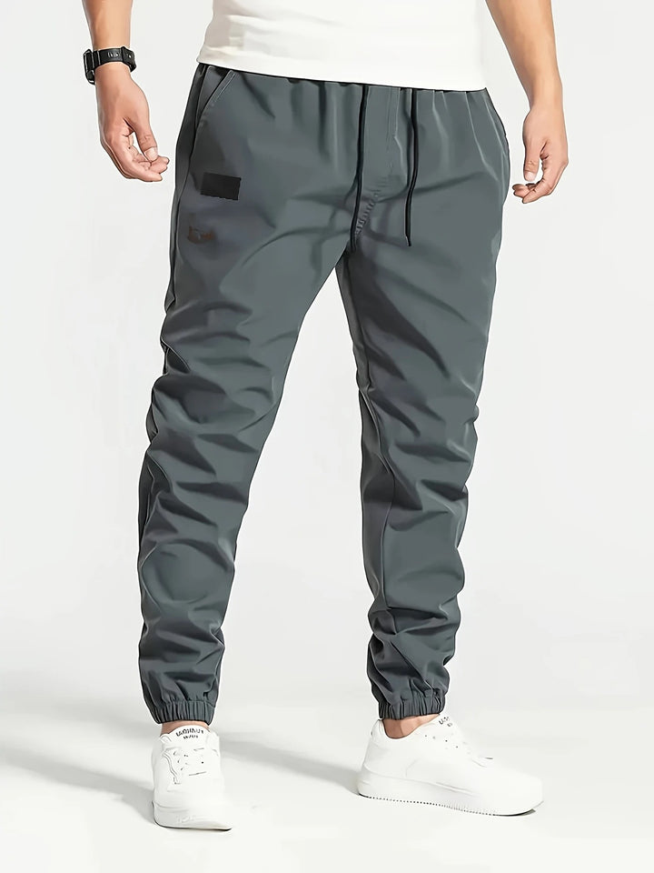 Herren Slim‑Tapered Tech‑Joggerhose mit Tunnelzugbund, elastischen Knöchelbündchen und funktionalen Seitentaschen Echo Archiv