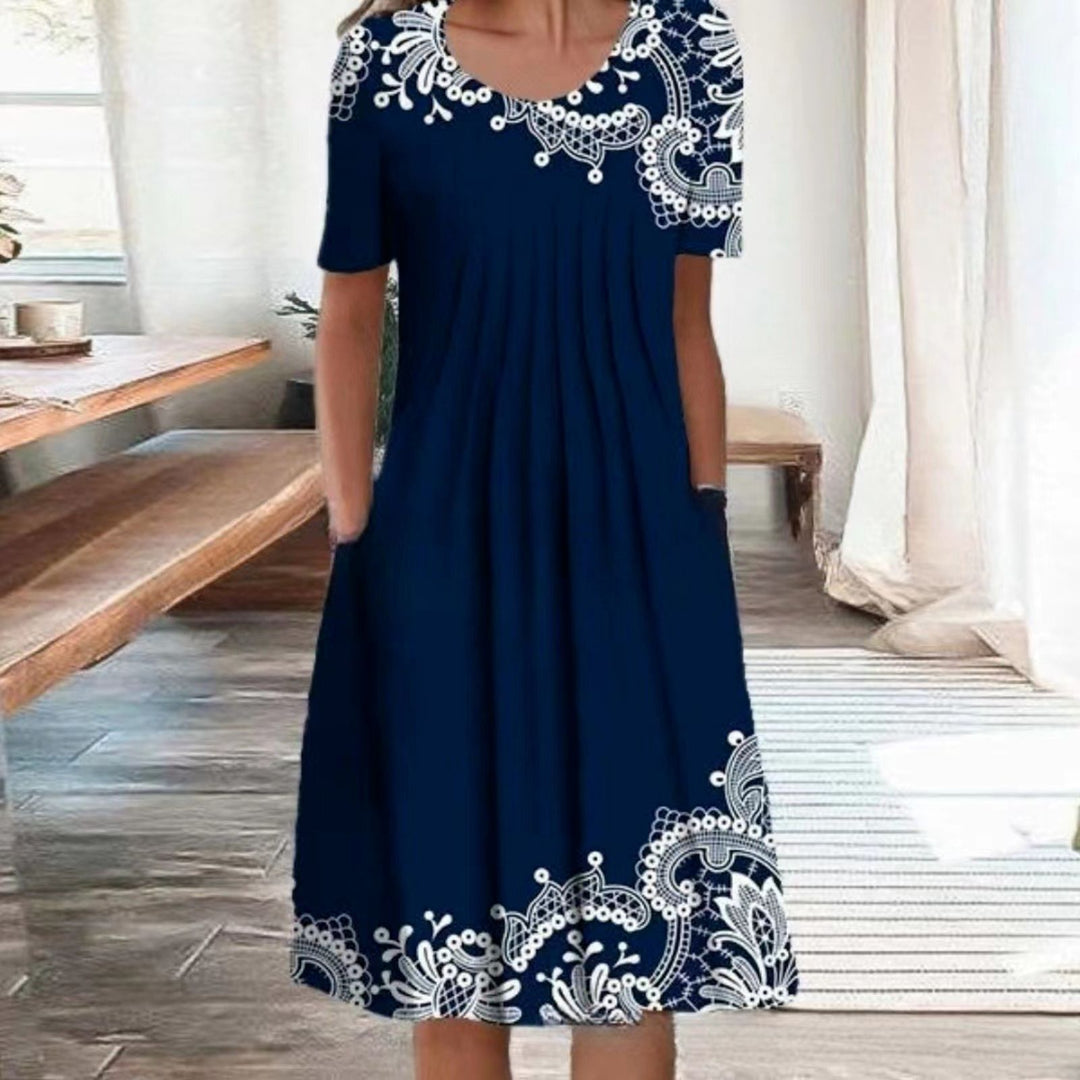 Damen Plissee Midi Kleid mit kurzen Ärmeln, seitlichen Taschen und floralem Saum – Élara