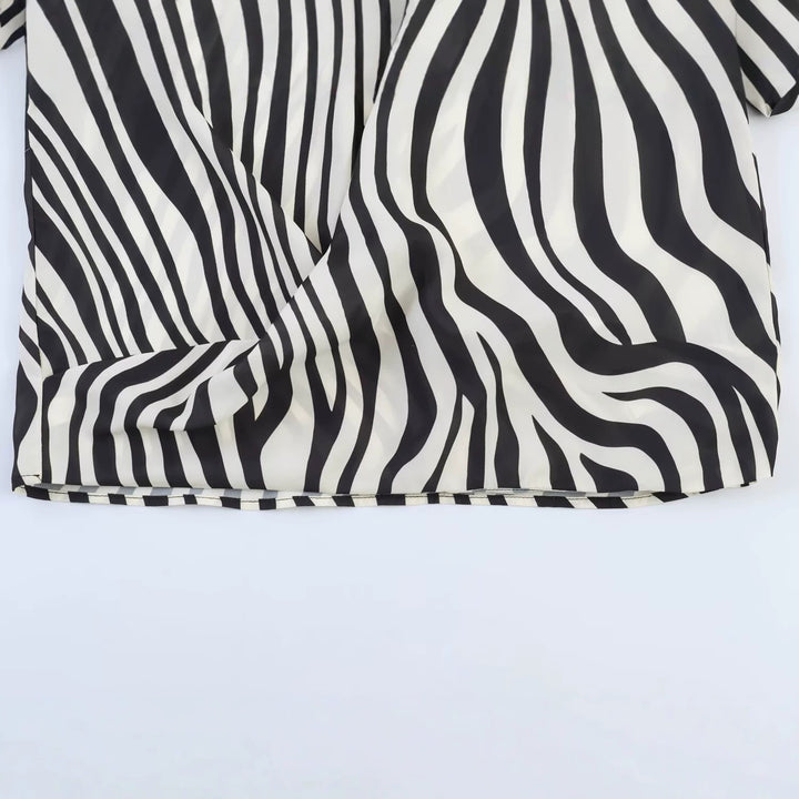 Damen Oversize-Satinbluse mit Hemdkragen, asymmetrischem Wickeleffekt und Federsaum Echo Archiv