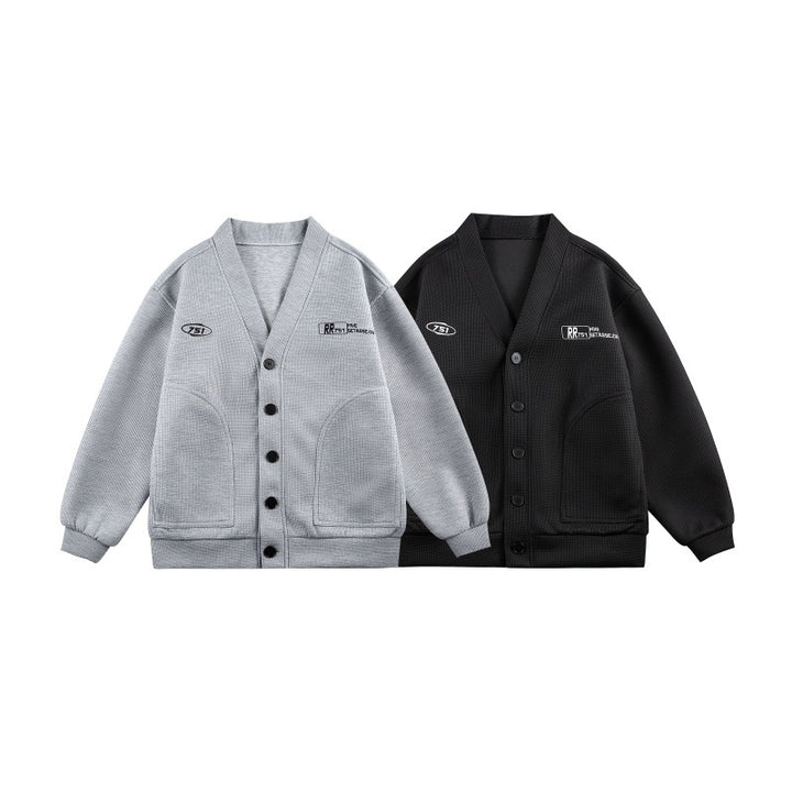 Unisex Boxy-Strickjacke im Waffelstrick mit V-Kragen, durchgehender Knopfleiste und aufgesetzten Rundtaschen Echoarchiv