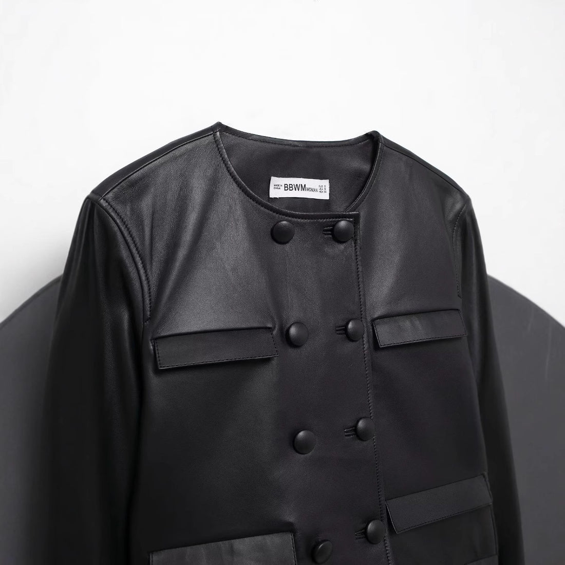 Damen cropped Kunstlederjacke mit Rundhalsausschnitt, doppelreihiger Knopfleiste und aufgesetzten Pattentaschen – Célinea