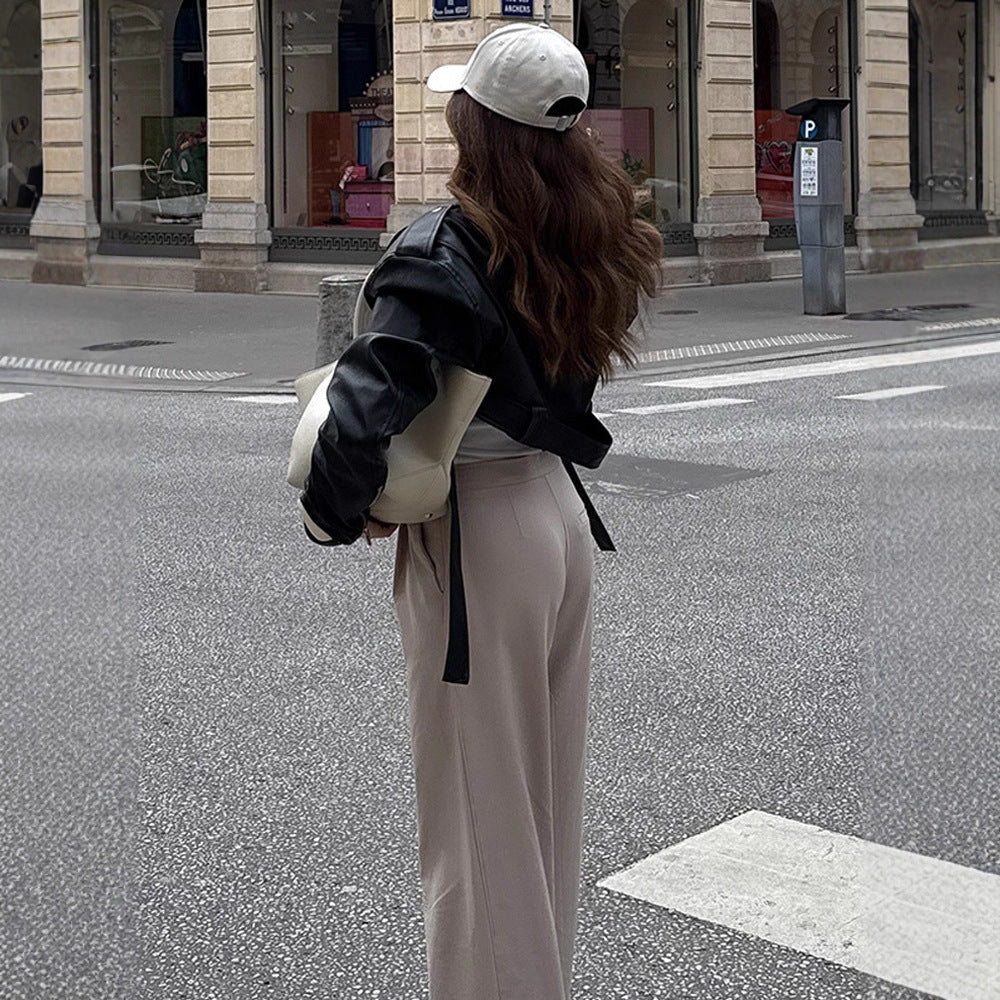 Damen Kurzgeschnittene Bikerjacke aus Kunstleder mit taillierendem Bindegürtel und markanten Epauletten Echoarchiv
