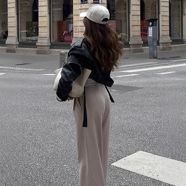 Damen Kurzgeschnittene Bikerjacke aus Kunstleder mit taillierendem Bindegürtel und markanten Epauletten Echoarchiv