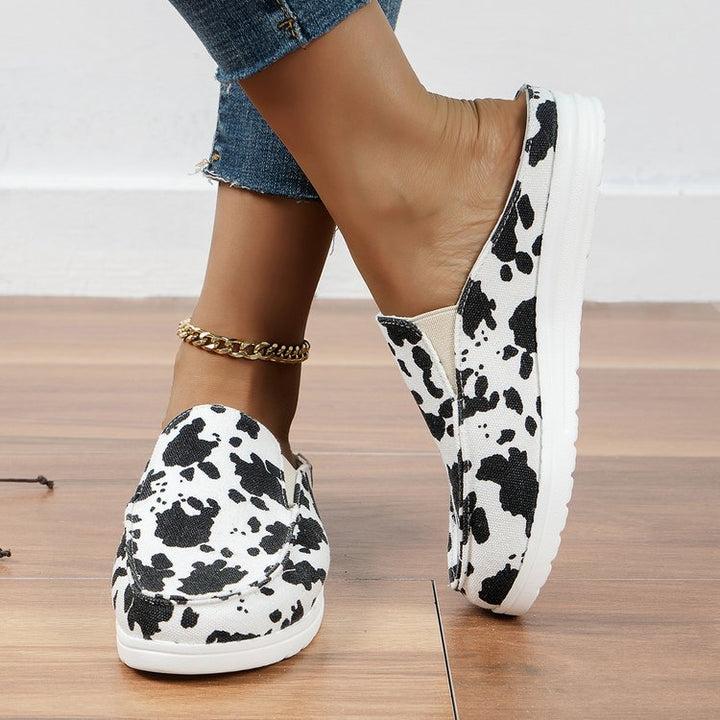 Damen  Slip-On Canvas‑Mules mit Kuhfleckenprint, gepolstertem Komfortfußbett und rutschfester Leichtsohle Echo Archiv