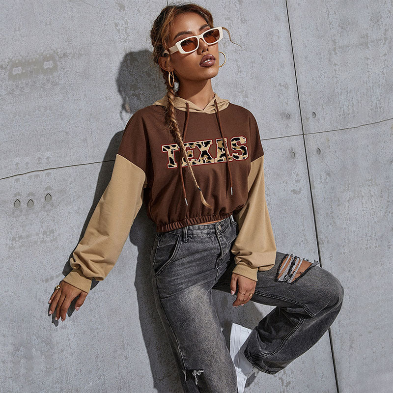 Damen Kurzgeschnittener Kapuzenpullover mit Teddy‑Print, Colorblock‑Ärmeln und elastischem Saum Echoarchiv