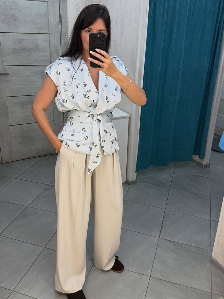 Damen Ärmellose Wickelbluse mit tailliertem Bindegürtel und Pattentaschen Echoarchiv
