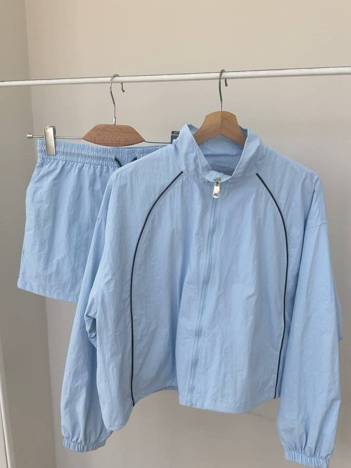 Damen gekürztes Windjacke-Set mit Stehkragen, kontrastierender Paspelierung und elastischer kurzer Freizeit-Hose – Célinea