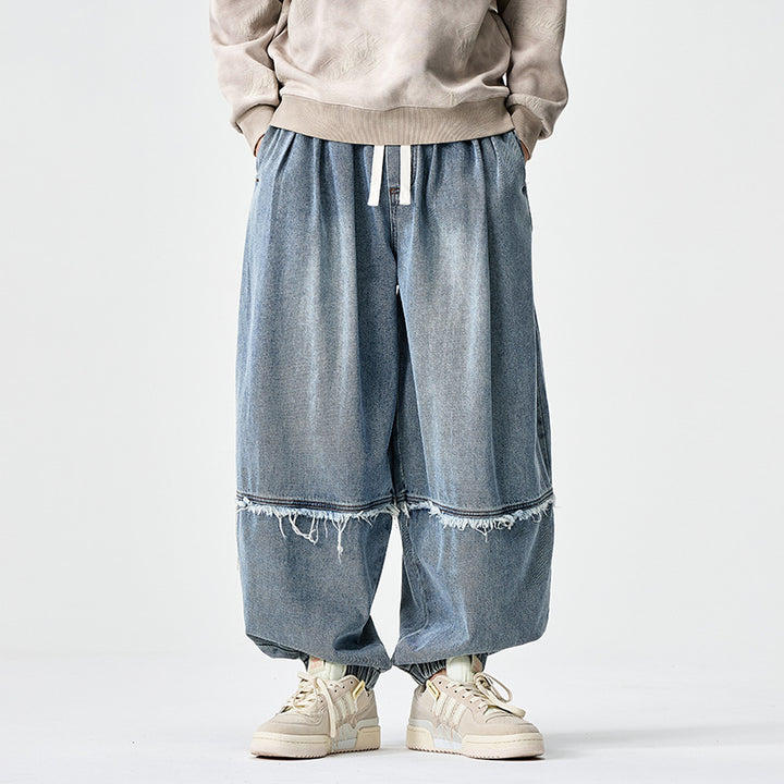 Herren Weit geschnittene Baggy-Denim-Hose mit Tunnelzug, elastischen Beinabschlüssen und Fransen-Detail Echo Archiv
