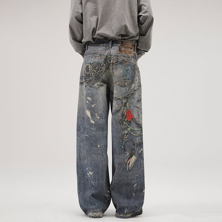 Herren Weit geschnittene Stonewashed-Denim-Jeans mit Kettenprint, Farb‑Splatter und bodenlangem Saum Echo Archiv