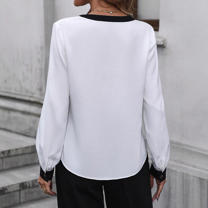 Damen Elegante V‑Ausschnitt-Bluse aus fließendem Stoff mit Kontrastpaspeln und Manschetten – Avérine