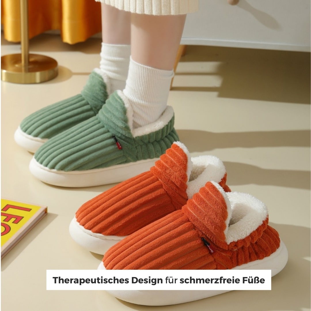 Warme grün und orange hausschuhe, die auf einem hellen boden liegen