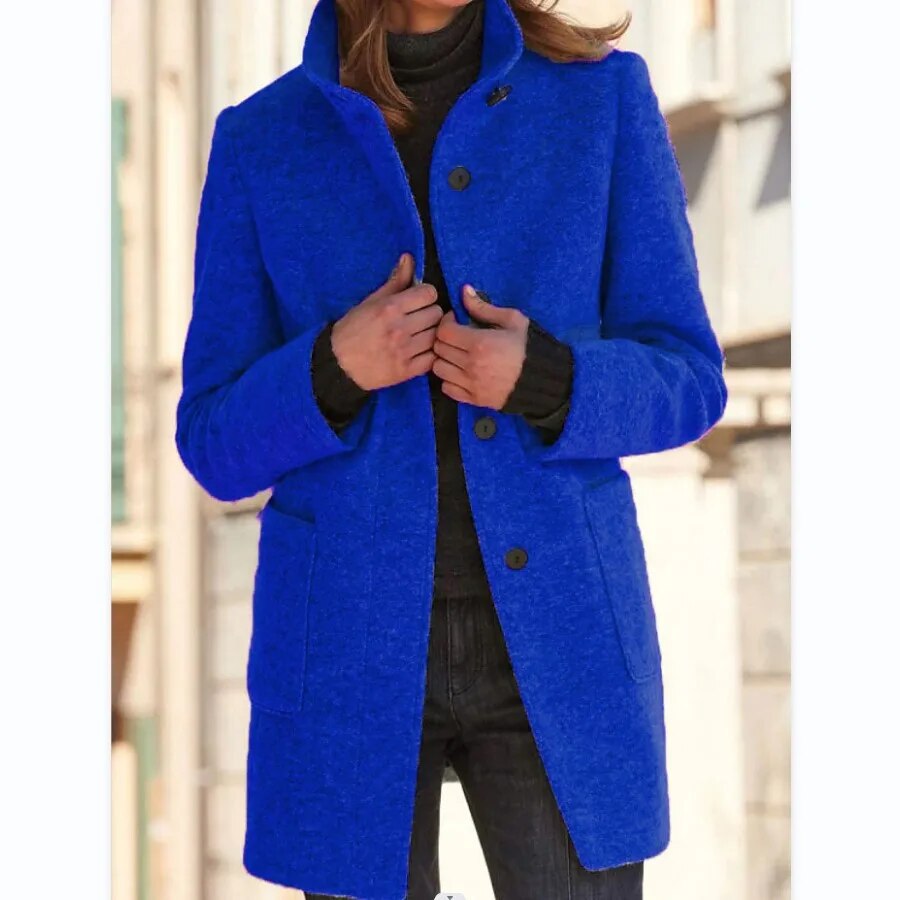 Blau­ eleganter wollmantel, getragen von einem model mit verschränkten händen