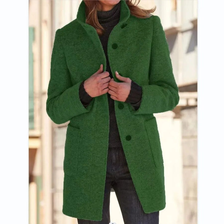 Grün eleganter wollmantel, getragen von einem model mit verschränkten händen